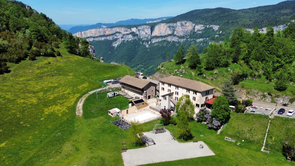 Vue aérienne de l'Hostel Quartier Libre au col de la Machine, face aux falaises du Vercors